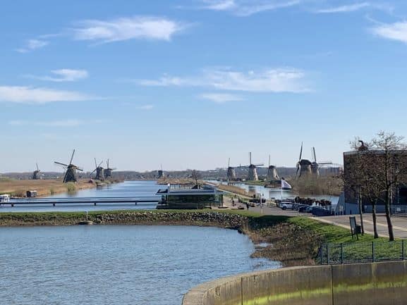 Zicht op de beroemde windmolens van Kinderdijk langs de waterweg, een erkend UNESCO Werelderfgoed, op een zonnige dag met een heldere hemel.