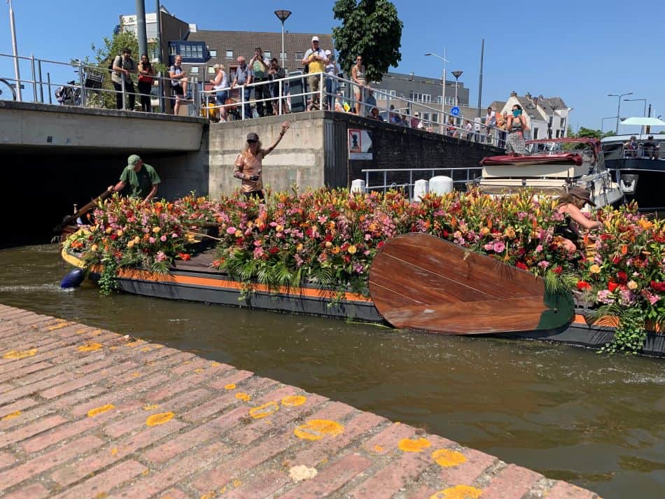 Een prachtige met bloemen versierde boot vaart door Delft tijdens het varend corso in 2023