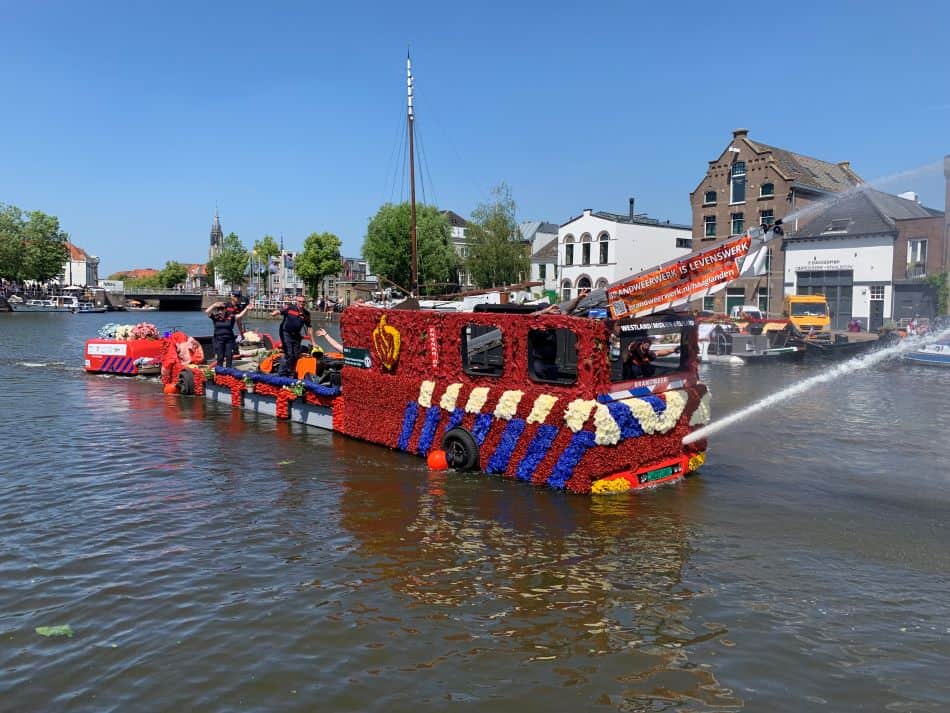 een als brandweertruck versierde boot vaart door Delft tijdens het varend corso in 2023